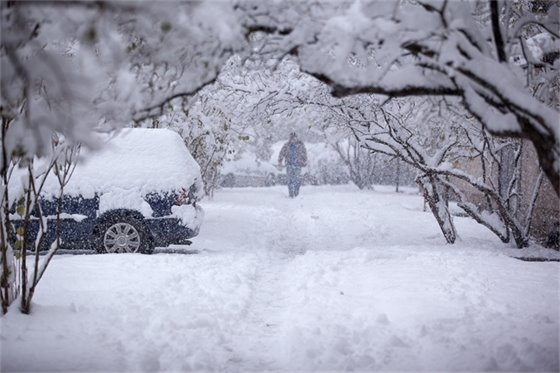 A person walking down the sidewalk in the snow